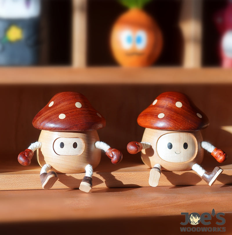 Pair of wooden mushroom dolls sitting on shelf with red caps and gloves