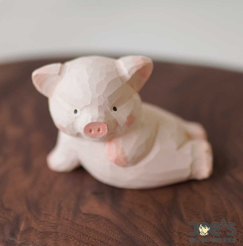 Front angle of pink piglet wood carving with hand-chiseled texture