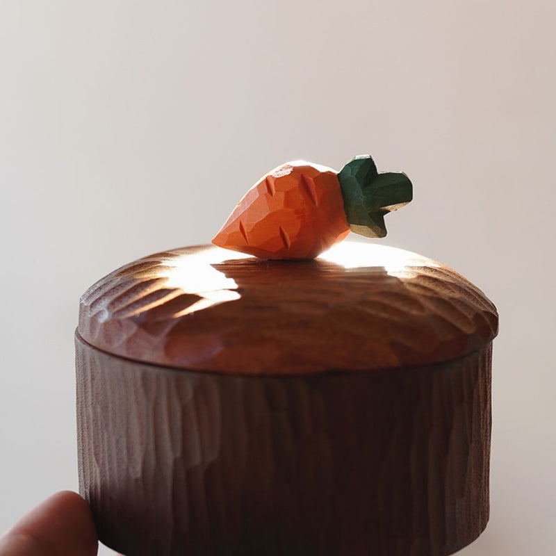 Pipimu carrot wooden jar with hand-carved lid in warm light, rustic handmade decor