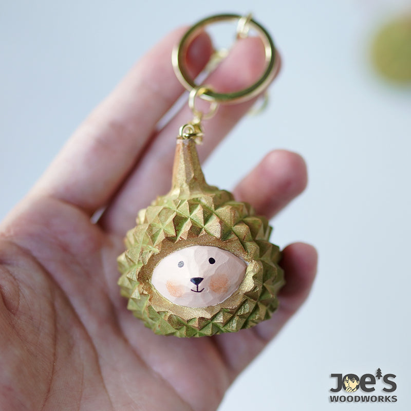 Hand holding Pipimu Dudu Durian keychain, showing size and texture