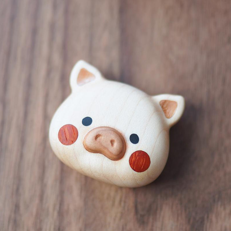 Close-up of Pipimu’s Poko wooden pig keychain with natural wood grain