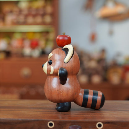 Side view of wooden red panda kitty figurine with striped tail