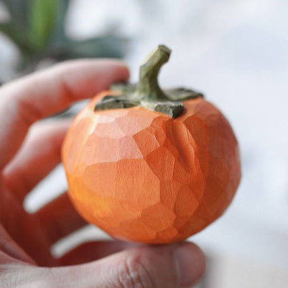Pipimu Sunny Persimmon wooden ornament with green leaf held in hand