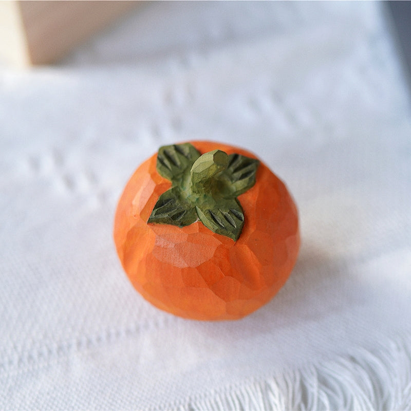 Top view: Pipimu Sunny Persimmon wooden ornament with green leaf detail