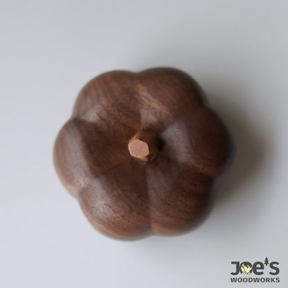 Top-down view of the hand-carved pumpkin box lid with hexagonal wooden stem detail