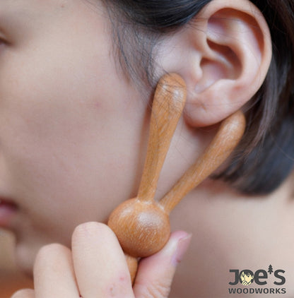 Using the wooden rabbit massage stick on face for gentle facial massage