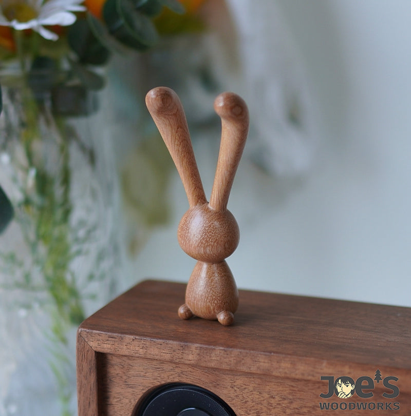 Front view of the wooden rabbit massage tool standing upright for display