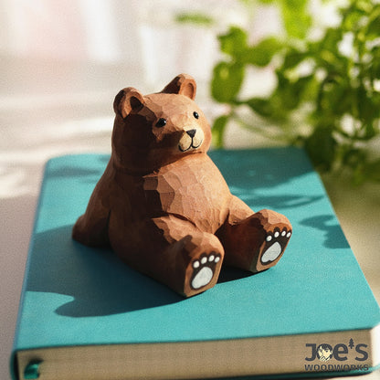 Cute wooden bear phone stand placed on a book, lovely as decor