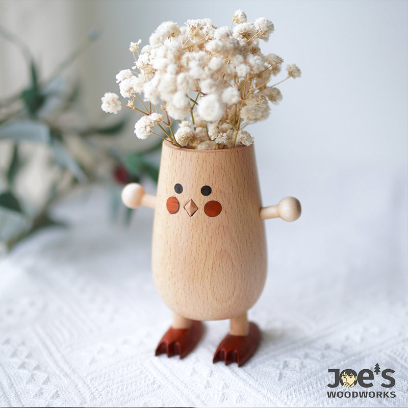 Wooden chick vase used as a dried flower arrangement container