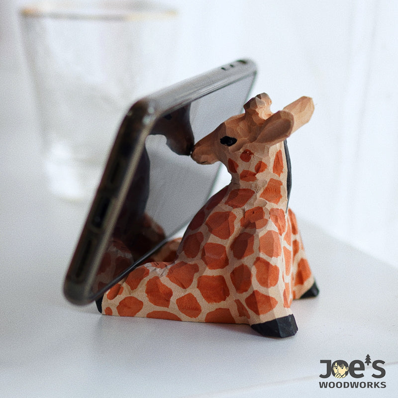 Handmade wooden giraffe phone holder in use on desktop, cute and functional stand