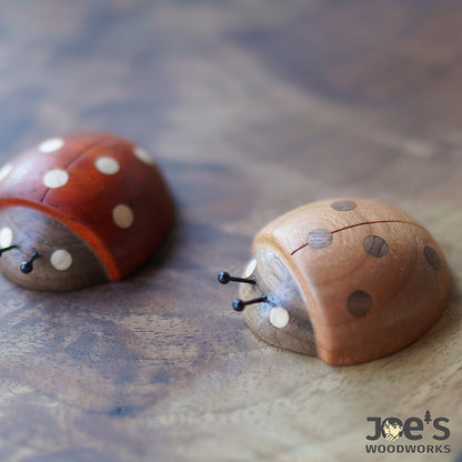 Close-up of hand-carved wooden ladybug magnets showing natural wood grain