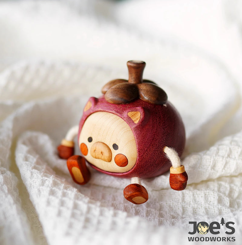 Side view of handmade wooden pig figurine in red fruit costume with dangling arms and legs