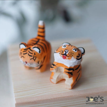Two wooden tiger figurines in sitting and standing pose, full of handmade charm