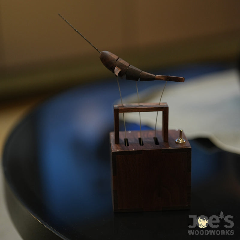 Wooden whale kinetic automaton placed on a black tabletop